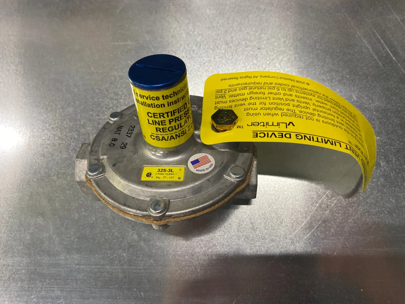 Gas line pressure regulator with its vent limiting device and yellow instruction tag
