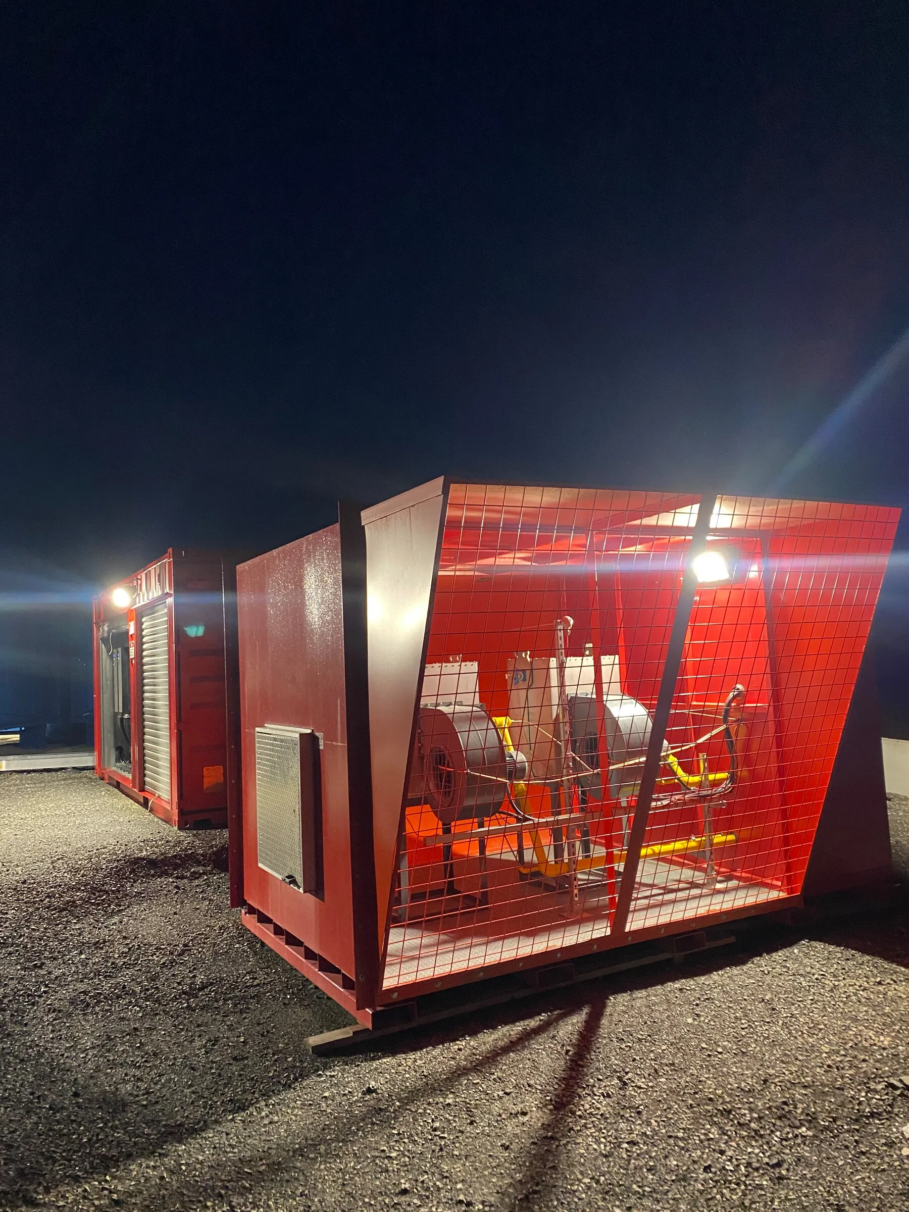 Two mine air heaters running overnight on a floodlit gravel pad at a mine site
