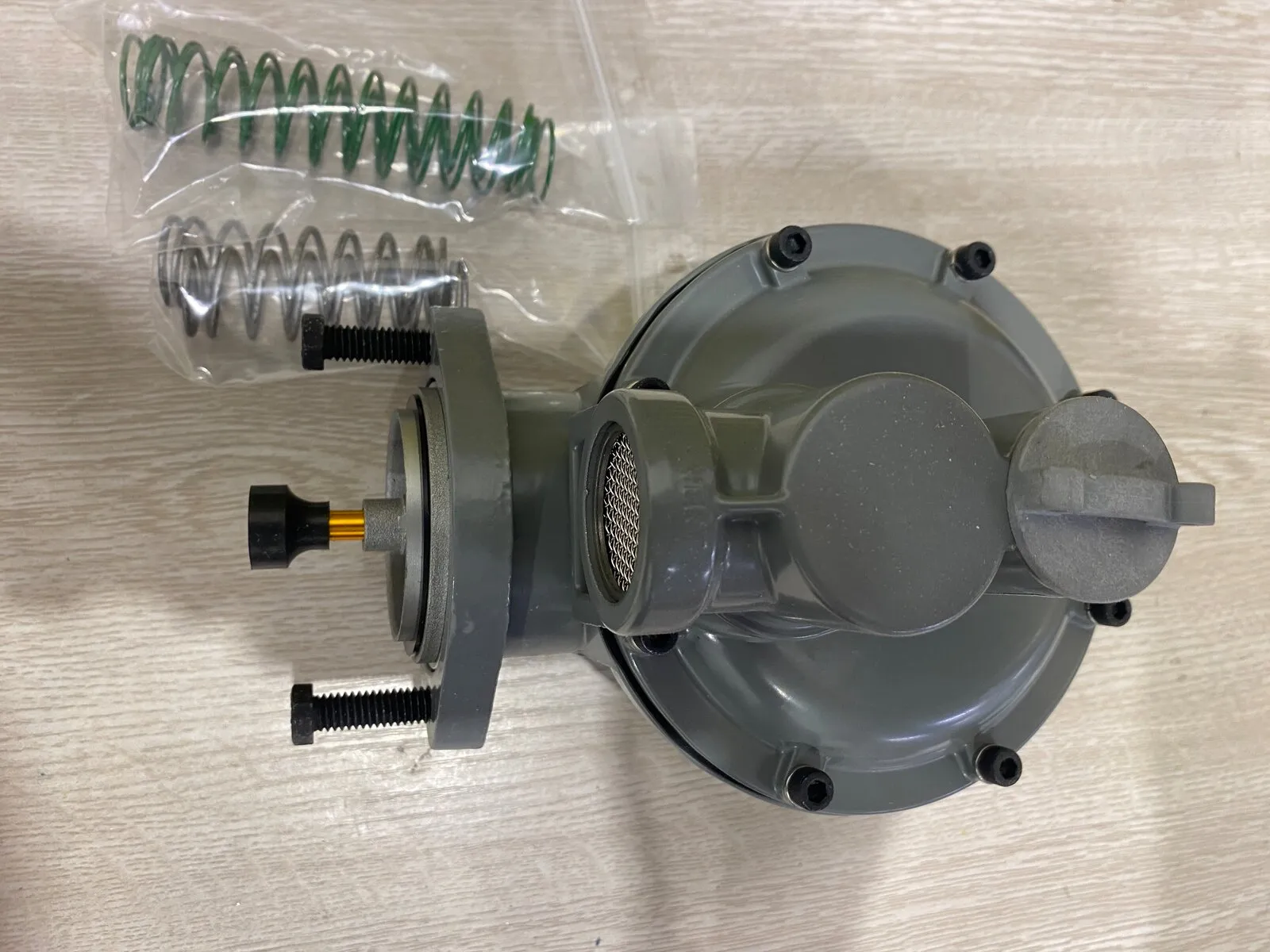 Gas pressure regulator opened up beside its replacement spring kit and orifice