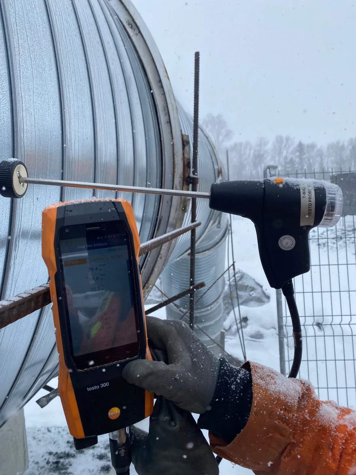 Technician taking flue gas readings with a combustion analyser during on-site commissioning