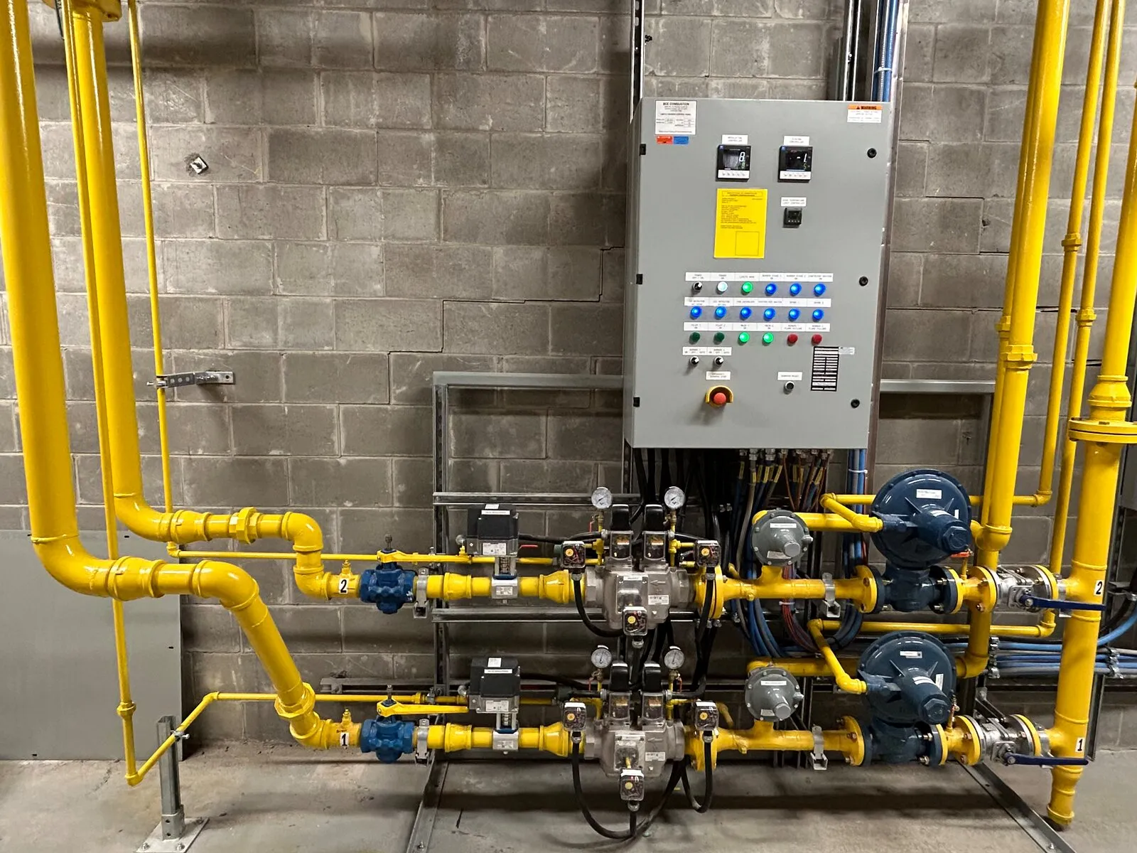 Burner management system panel and gas train installed on a plant wall