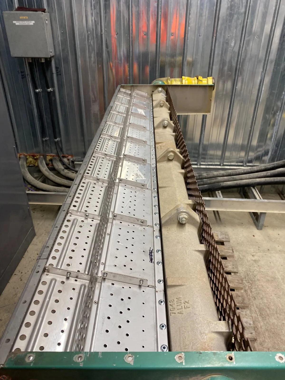 Burner manifold being rebuilt on site, inside a metal-clad heater room