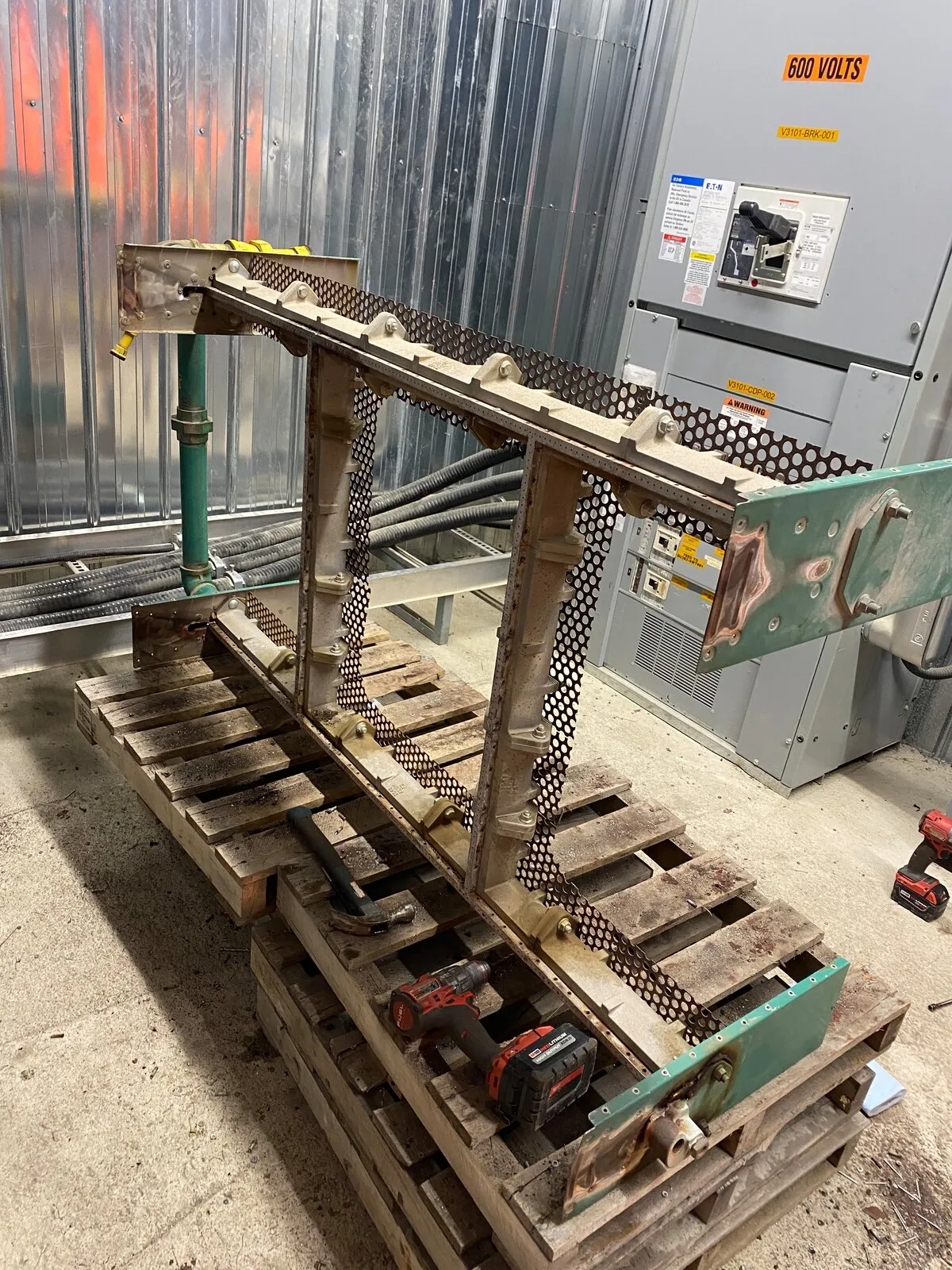 Custom heater burner frame on pallets with hand tools, being rebuilt on site