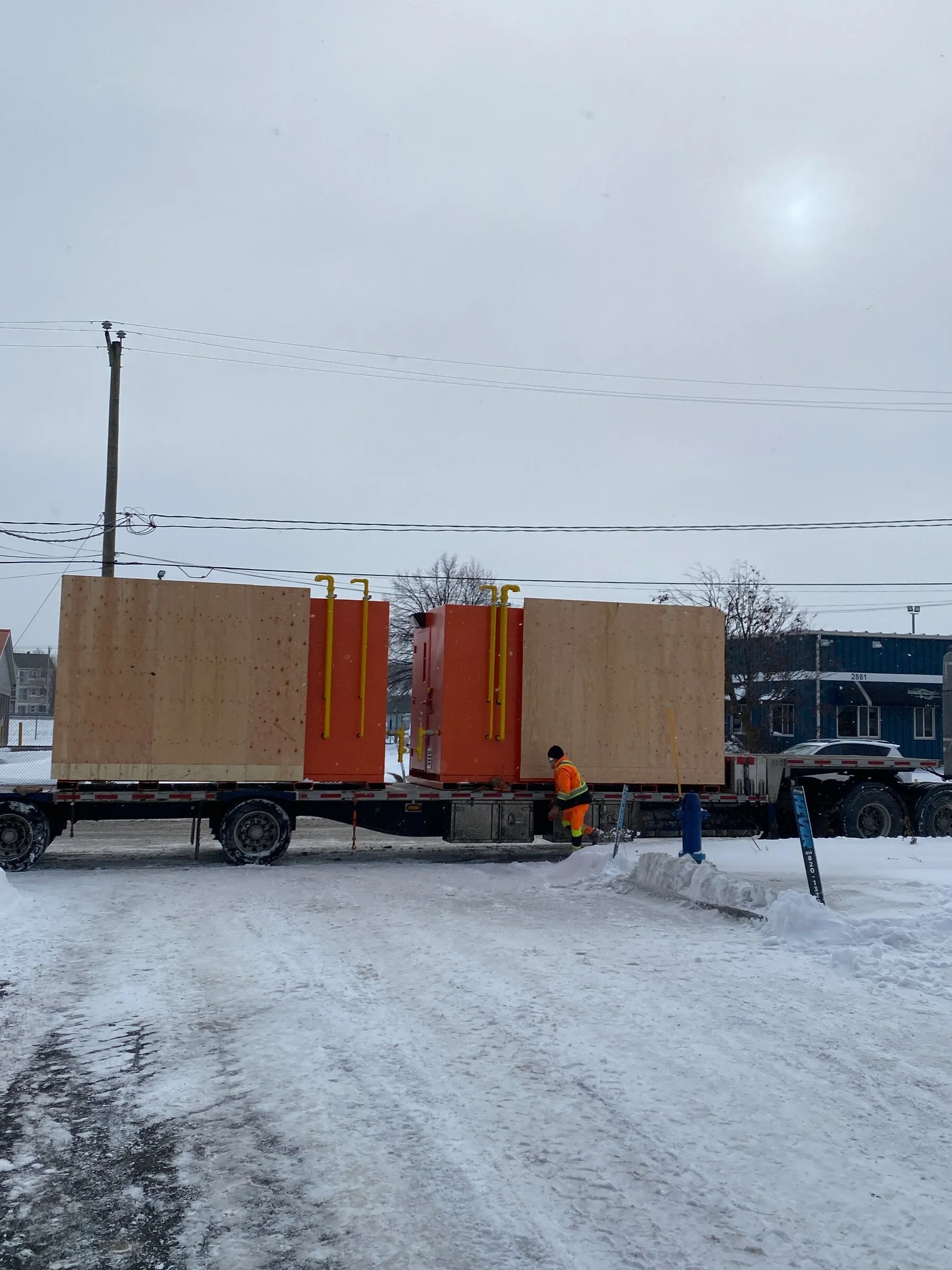 Two crated mine air heaters loaded on a flatbed for delivery in winter